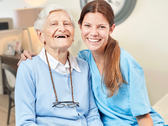 Senior living in a retirement home in Ontario sitting with nurse smiling