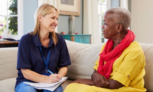 Senior chatting with young woman in a retirement home in Ontario. They seem happy and enjoying their conversation.